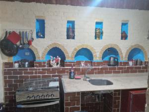 cocina con pared de ladrillo y fregadero en Green Palace Garden, en Luxor 17 fotos más