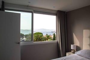 1 dormitorio con ventana y vistas al océano en Sérénité Marines ‣Incredible Sea view en Saint-Tropez
