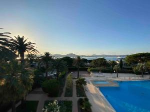 - une vue sur un complexe avec une piscine et des palmiers dans l'établissement Sérénité Marines ‣Incredible Sea view, à Saint-Tropez