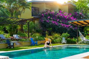 Una donna in bikini seduta in piscina di Rinconcito Lodge a Hacienda Santa María