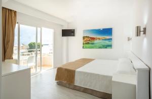 - une chambre blanche avec un lit et une vue sur l'océan dans l'établissement Hotel Kilimanjaro, à El Arenal