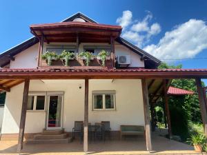 a house with a balcony with plants on it at Guesthouse Abrlic in Seliste Dreznicko