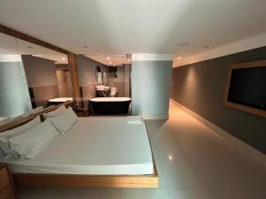 um quarto com uma cama e uma casa de banho com uma televisão em HOTEL PORTELÃO no Rio de Janeiro