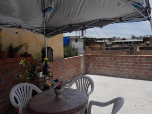 een tafel en stoelen onder een parasol op een patio bij AKAO HOUSE in Arequipa