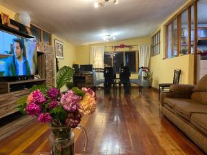 a living room with a tv and a vase of flowers at MY WAY Apartment in Cusco