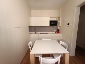 een keuken met een witte tafel en witte stoelen bij Chill in Tuscany ground floor in Lucca