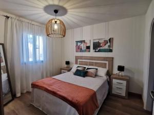 una camera con un grande letto e un lampadario a braccio di Montes Blancos a Costa Calma