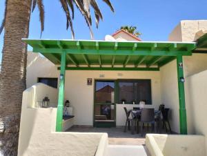 un pergolato verde su un patio con tavolo di Montes Blancos a Costa Calma