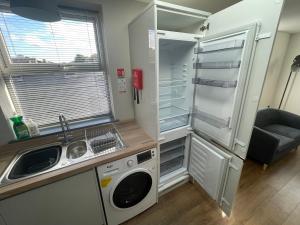 a small kitchen with a refrigerator and a sink at Spacious 1 bedroom apartment in Bolsover in Chesterfield
