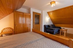 een slaapkamer met een bed en een stoel bij Apartment Vidmar in Bohinj