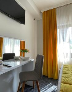 サラエボにあるBed & Breakfast Sjajのテーブル、椅子2脚、ベッド1台が備わる客室です。