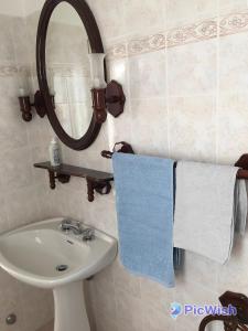 La salle de bains est pourvue d'un lavabo, d'un miroir et de serviettes. dans l'établissement Casa RODA Umbria 1Km da Toscana, à Castiglione del Lago
