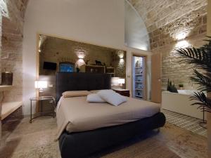 a bedroom with a large bed and a stone wall at Alle volte Maison deluxe in Giovinazzo
