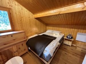 ein Schlafzimmer mit einem Bett in einer Holzhütte in der Unterkunft Chalet Châtel, 5 pièces, 8 personnes - FR-1-198-220 in Châtel
