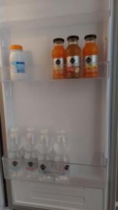 an open refrigerator filled with lots of bottles of juice at Appartamento L'Airone Cenerino in Canzo