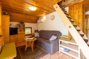 a living room with a couch and a staircase at Apartma Metka in Bohinj