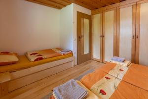 a bedroom with two beds and a wooden floor at Apartma Metka in Bohinj