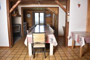 a dining room with a table and chairs and a clock at CHALET LA RIOULE 16 pers in Doucy