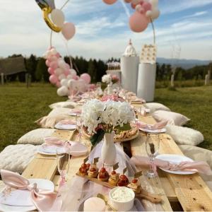 una mesa de picnic con platos, flores y globos en Vikendica Fenix, en Banja Luka