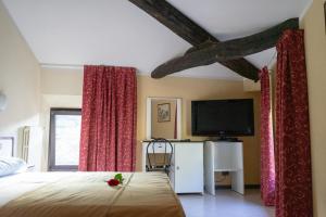 um quarto com uma cama e uma televisão de ecrã plano em Hotel Italia em Porretta Terme