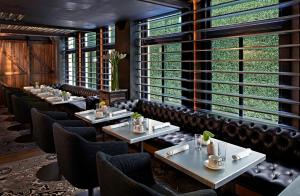 a restaurant with tables and chairs and large windows at Hotel Zelos San Francisco in San Francisco