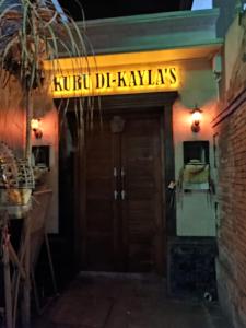 una porta per un ristorante con un cartello sopra di Kubu Di-Kayla's a Sanur