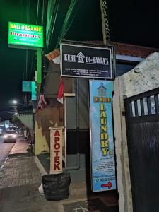 a group of signs on the side of a building at Kubu Di-Kayla's in Sanur