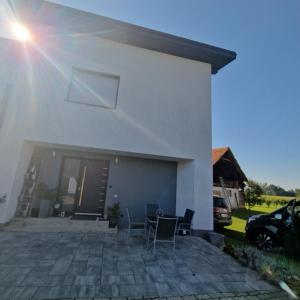 a white house with chairs and a patio at Ferienwohnung Ruß in Bad Radkersburg