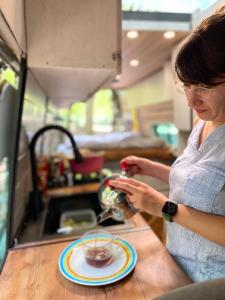 una mujer parada en un mostrador con un tazón de comida en best camper van in tbilisi, en Tiflis