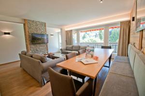 ein Wohnzimmer mit einem Tisch, Stühlen und einem Sofa in der Unterkunft Haus Matten, Apartment Breithorn in Zermatt