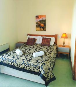 um quarto com uma cama com duas almofadas em The Falls - Value Rooms at Aultnagar Estate em Lairg