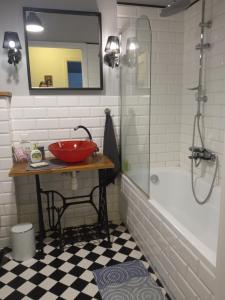 a bathroom with a red bowl on a table next to a tub at NightHost - Kleczkowska 49 in Wrocław