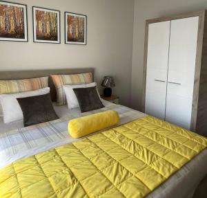 サラエボにあるBed & Breakfast Sjajのベッドルーム1室(黄色の毛布付きのベッド2台付)