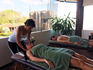 two people laying on beds in a room at Ara Merú Lodge in Canaima
