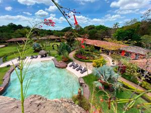 una piscina en un jardín con un complejo en Ara Merú Lodge, en Canaima