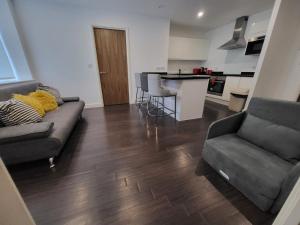 a living room with a couch and a kitchen at Vetrelax Basildon City Apartment in Basildon