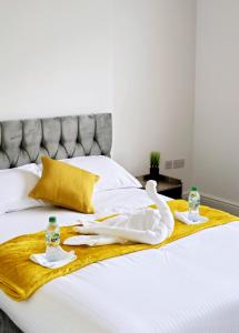 a bed with towels and bottles on top of it at The Private Rooms in Paddington in London