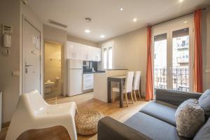 een woonkamer met een bank en een tafel en een keuken bij Catalunya Casas 2 bed apartment in Barceloneta steps from the beach in Barcelona