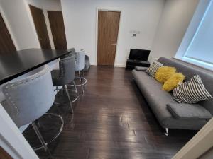 a living room with a couch and a table at Vetrelax Basildon City Apartment in Basildon