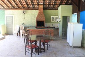 a kitchen with a table and chairs and a refrigerator at Pousada Praia Enseada - Marvile in Guarujá