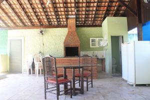 a kitchen with a table and chairs and a fireplace at Pousada Praia Enseada - Marvile in Guarujá