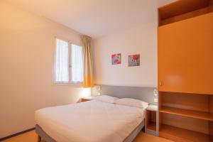 a small bedroom with a bed and a window at VVF Résidence Pays Basque Saint-Jean-Pied-de-Port in Saint-Jean-Pied-de-Port
