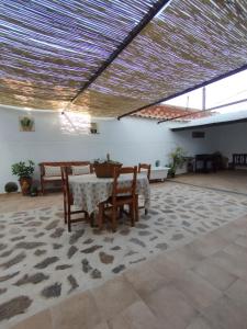 Habitación con mesa, sillas y techo. en Casa Doña Gumersinda, en San Carlos del Valle