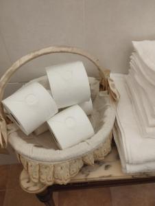 una cesta llena de toallas blancas sentadas junto a una cama en Casa Doña Gumersinda, en San Carlos del Valle