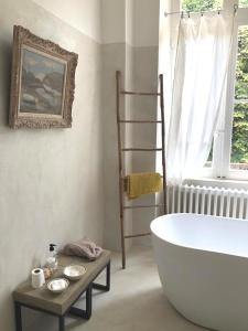 a bathroom with a large white tub and a window at B&B Maison Felisa in Sabran