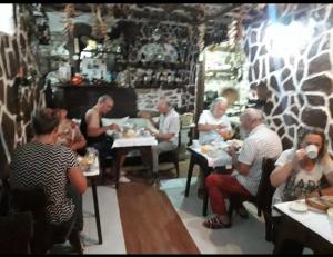 a group of people sitting at tables in a restaurant at Hotel Nasho Vruho in Berat