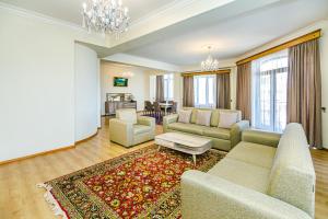 uma sala de estar com um sofá, cadeiras e um tapete em Luxary Home Millennium em Baku