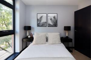 ロンドンにあるThe Whitechapel Place - Stunning 2BDR Flat with Balconyのベッドルーム1室(ベッド1台付)が備わります。壁に2枚の写真が飾られています。