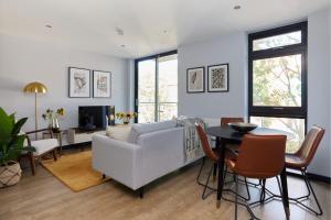 a living room with a couch and a table at The Whitechapel Place - Stunning 2BDR Flat with Balcony in London