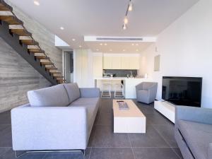 uma sala de estar com um sofá e uma televisão em Sunset Park Villas em Pafos